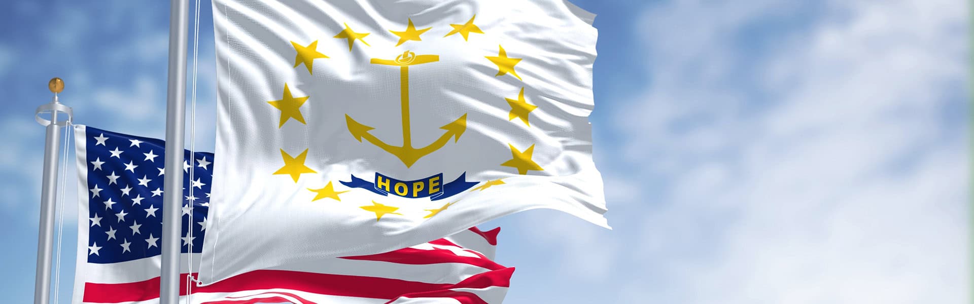 The Rhode Island state flag waving along with the national flag of the United States of America / shutterstcok.com