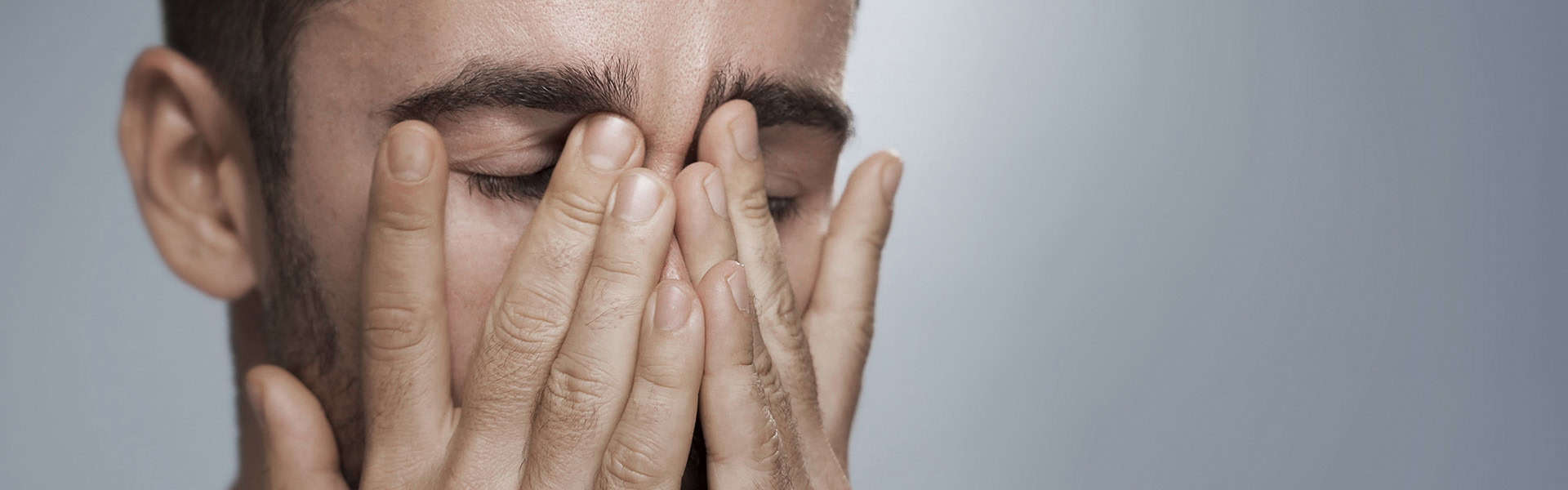 Photo of a man covering his face in frustration / shutterstock.com